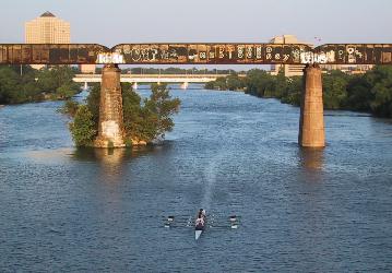 The University of Texas Womens Rowing Team passes under the Trestle on the Colorado River