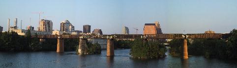 The Train Trestle from the West side where it crosses the Colorado River.  It's rusty looking with a bit of graffiti, downtown Austin in the background.